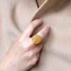 aurea-amber-02-persconek-z-bursztynem2s Pierścionek Aurea 02 z kolekcji Aurea Amber z naturalnym bursztynem noszony na dłoni — okrągła forma i ciepły, złocisty odcień kamienia.
